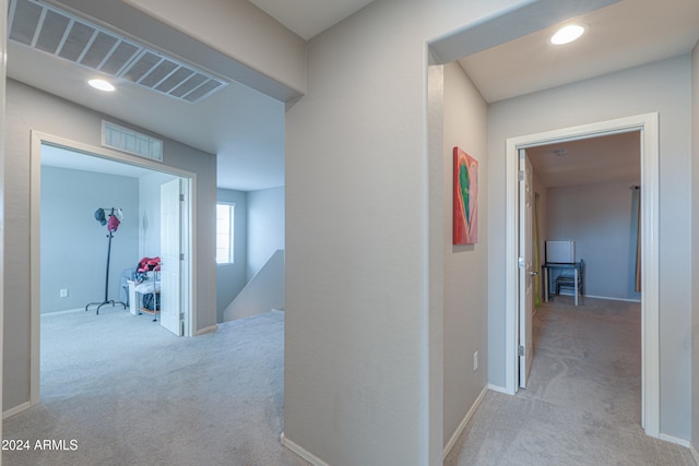 hallway featuring light colored carpet