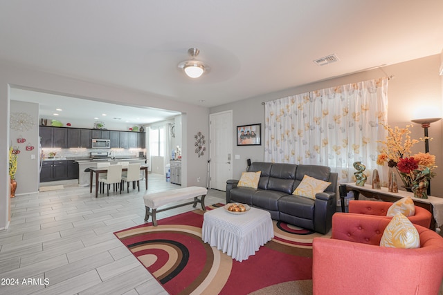 living room featuring light wood-type flooring and ceiling fan