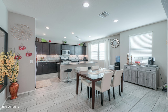 dining space with sink and light hardwood / wood-style flooring