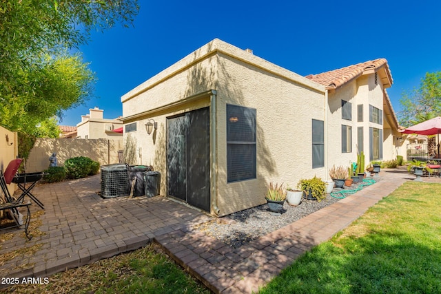 back of house with a patio area, stucco siding, a tile roof, and fence