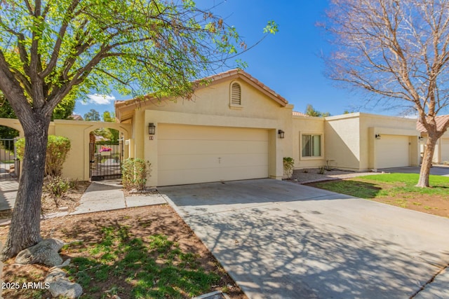 view of front facade featuring a gate, driveway, stucco siding, a garage, and a tile roof