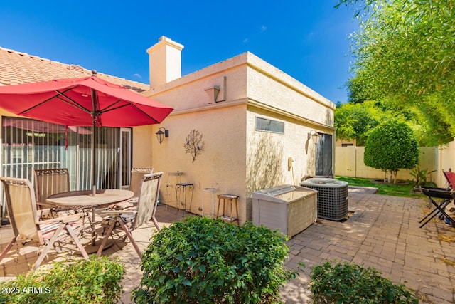 view of patio / terrace with cooling unit and fence