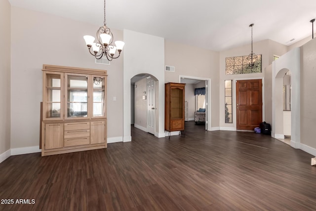 entrance foyer featuring visible vents, arched walkways, and dark wood-style floors