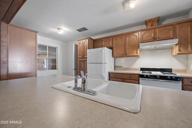 kitchen with white refrigerator, sink, and stove