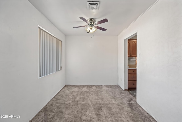 spare room featuring ceiling fan and light carpet