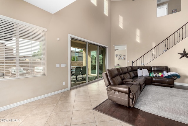 living room with light tile patterned floors and a towering ceiling