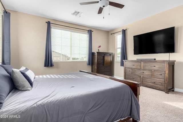 bedroom with multiple windows, light colored carpet, and ceiling fan