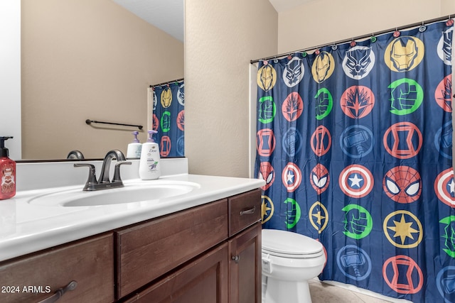 bathroom with tile patterned flooring, vanity, and toilet