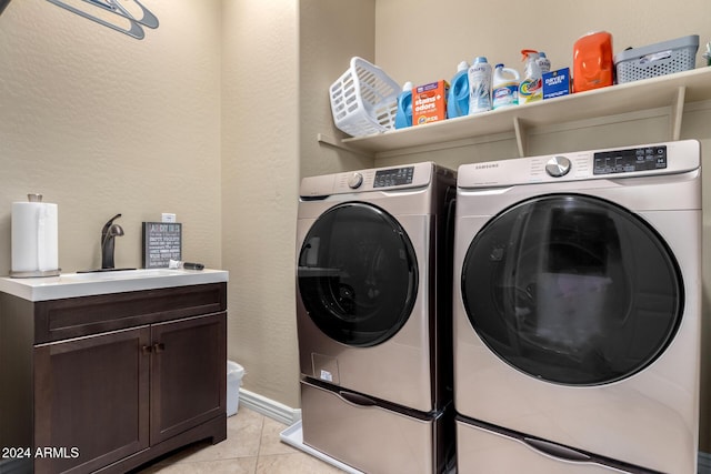 laundry area featuring separate washer and dryer, sink, light tile patterned floors, and cabinets