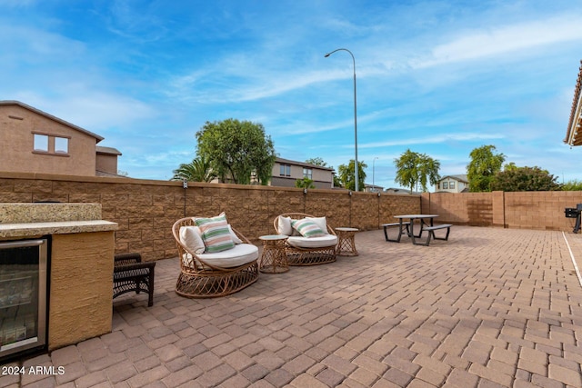 view of patio featuring an outdoor living space and beverage cooler