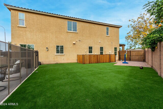 rear view of property featuring a lawn