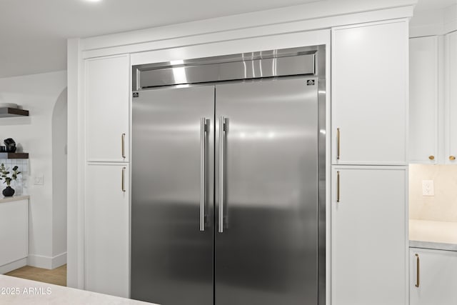 kitchen featuring light countertops, white cabinets, stainless steel built in fridge, and open shelves