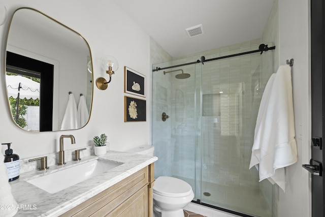 full bath featuring toilet, a shower stall, visible vents, and vanity