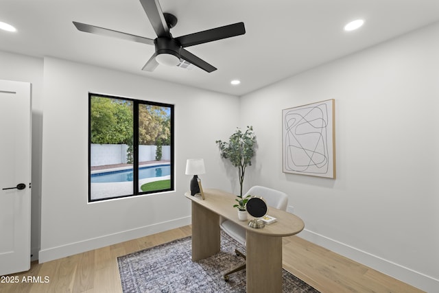 office space featuring light wood finished floors, baseboards, a ceiling fan, and recessed lighting