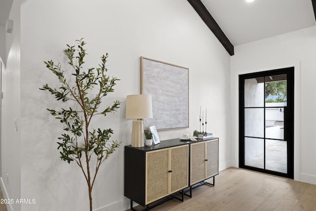 office area featuring lofted ceiling with beams, light wood-style floors, and baseboards