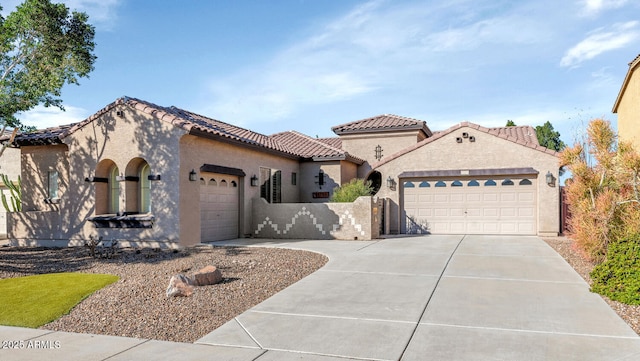 mediterranean / spanish-style house featuring an attached garage, fence, driveway, a tiled roof, and stucco siding