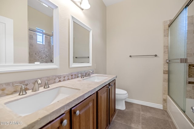 full bathroom featuring baseboards, combined bath / shower with glass door, a sink, and toilet