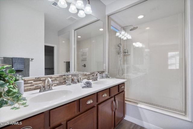 bathroom with vanity, decorative backsplash, and a tile shower