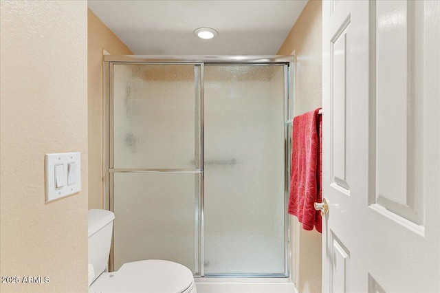 bathroom with walk in shower and toilet