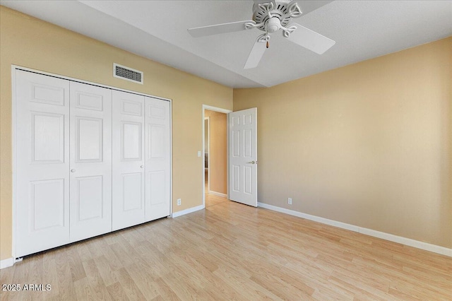 unfurnished bedroom featuring ceiling fan, a closet, and light hardwood / wood-style flooring