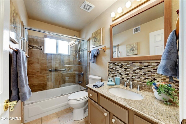 full bathroom with tile patterned floors, toilet, vanity, enclosed tub / shower combo, and backsplash