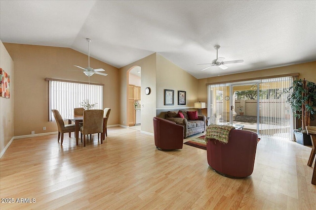 living room featuring lofted ceiling, light hardwood / wood-style flooring, and ceiling fan