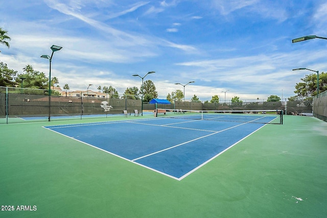 view of tennis court featuring basketball hoop