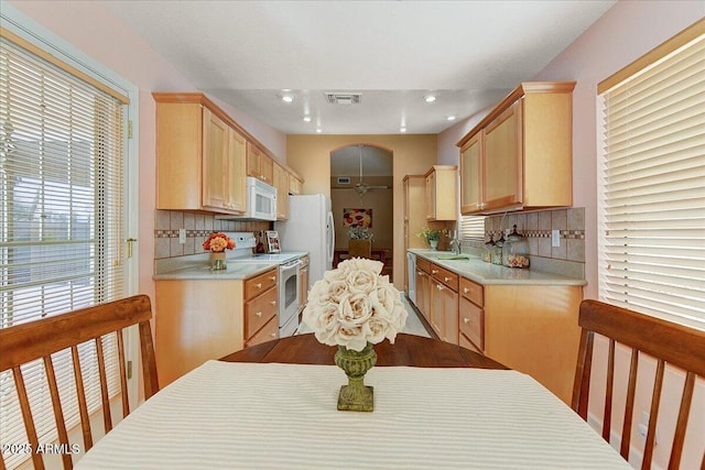 kitchen featuring tasteful backsplash, sink, white appliances, and light brown cabinets