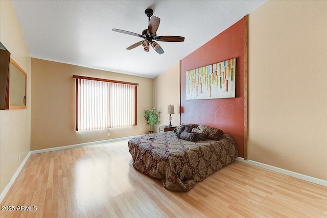 bedroom featuring hardwood / wood-style floors, vaulted ceiling, and ceiling fan