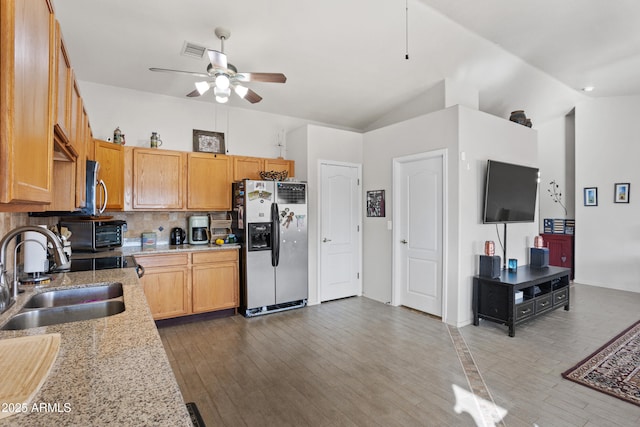 kitchen with stainless steel appliances, lofted ceiling, sink, and decorative backsplash