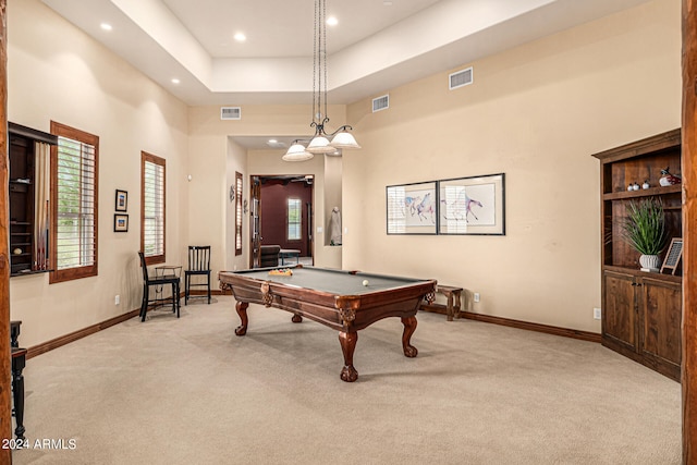 rec room with light colored carpet, pool table, a tray ceiling, and a high ceiling