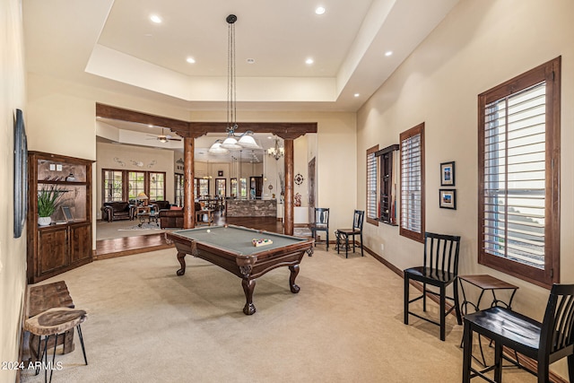 rec room with a raised ceiling, light colored carpet, and billiards