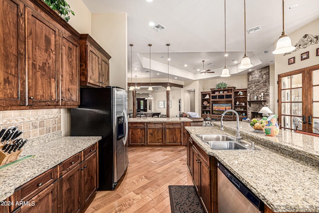 kitchen featuring light hardwood / wood-style flooring, tasteful backsplash, hanging light fixtures, appliances with stainless steel finishes, and sink