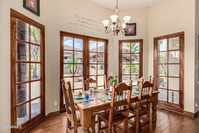 dining area featuring dark wood-type flooring and a notable chandelier