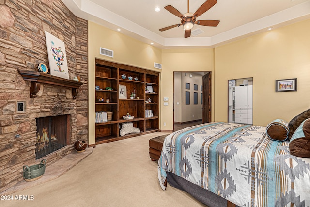 bedroom with carpet floors, ceiling fan, and a fireplace