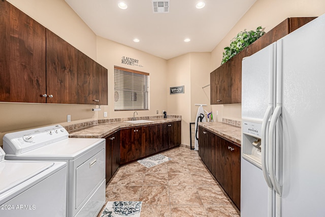 clothes washing area with sink, washer and dryer, and light tile patterned floors