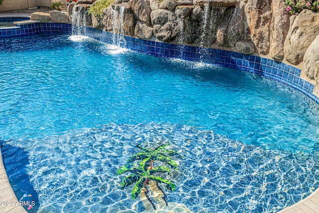 view of swimming pool with pool water feature