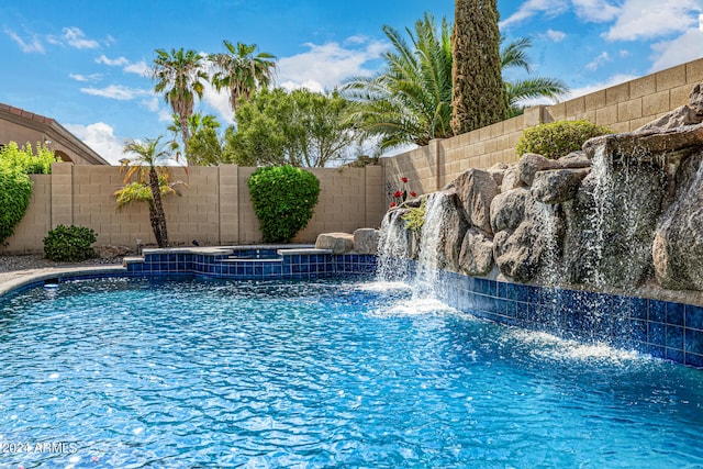 view of pool featuring pool water feature and an in ground hot tub