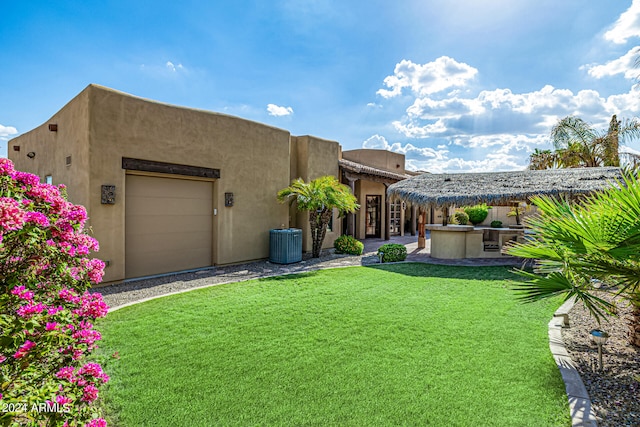 view of yard featuring central AC unit and a garage