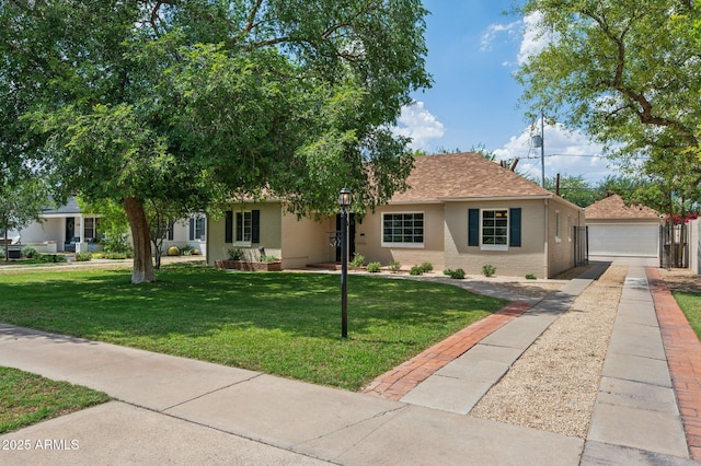 522 W Cambridge Ave, Phoenix, AZ 85003 - view of front facade with a garage, a front yard, a shingled roof, and an outbuilding
