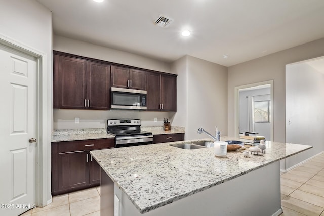 kitchen featuring light tile patterned floors, dark brown cabinets, visible vents, appliances with stainless steel finishes, and a sink