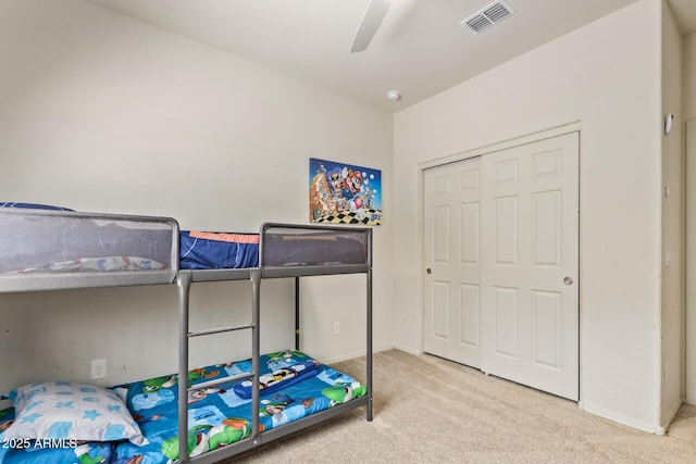 carpeted bedroom featuring visible vents, baseboards, a ceiling fan, and a closet