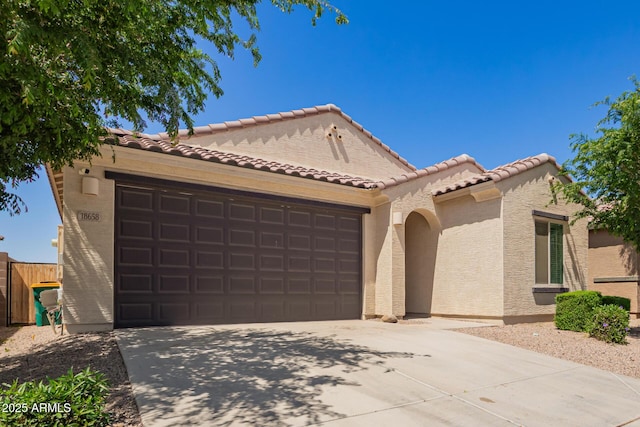 mediterranean / spanish house featuring concrete driveway, a tile roof, a garage, and stucco siding