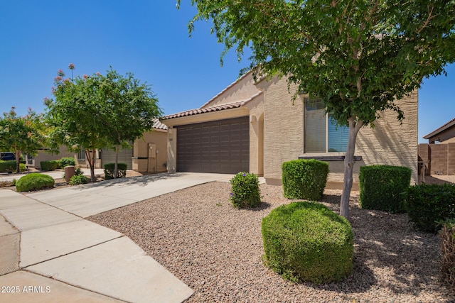 view of front of house featuring a garage, stucco siding, concrete driveway, and a tile roof
