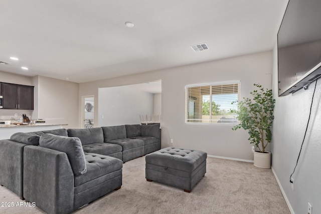 living room with visible vents, baseboards, recessed lighting, and light carpet