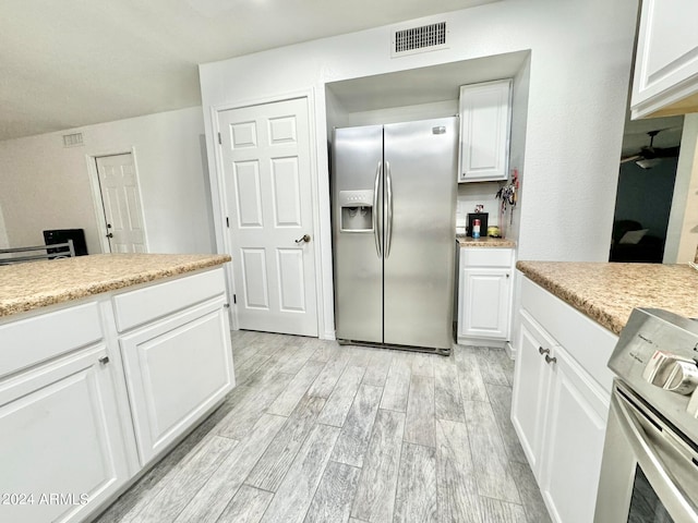 kitchen featuring white cabinetry, light hardwood / wood-style floors, appliances with stainless steel finishes, and ceiling fan