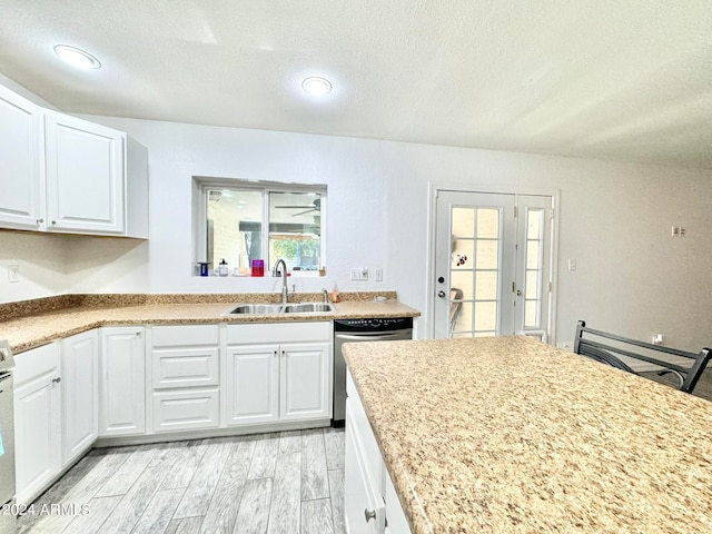 kitchen featuring sink, a textured ceiling, white cabinetry, appliances with stainless steel finishes, and light hardwood / wood-style floors