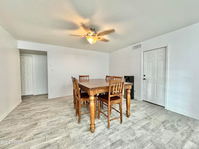 dining room featuring a textured ceiling, ceiling fan, and light hardwood / wood-style flooring