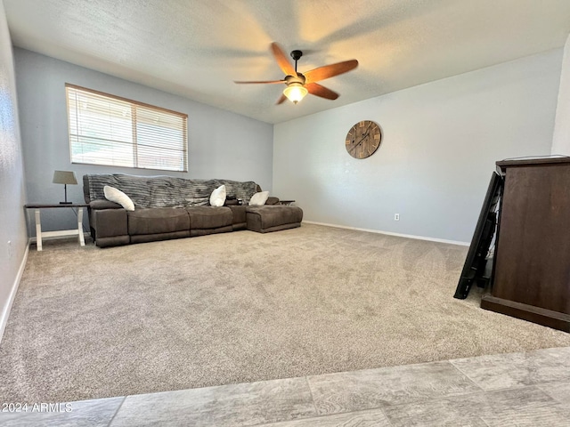 carpeted living room with a textured ceiling and ceiling fan