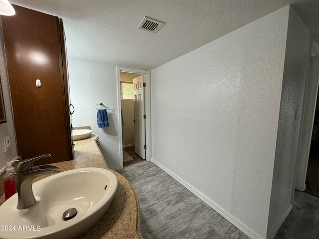 bathroom featuring a textured ceiling and sink